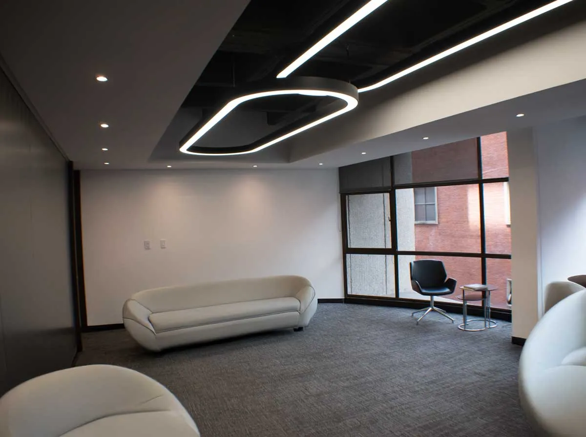 Zona de oficina con sofá blanco y luminaria circular
